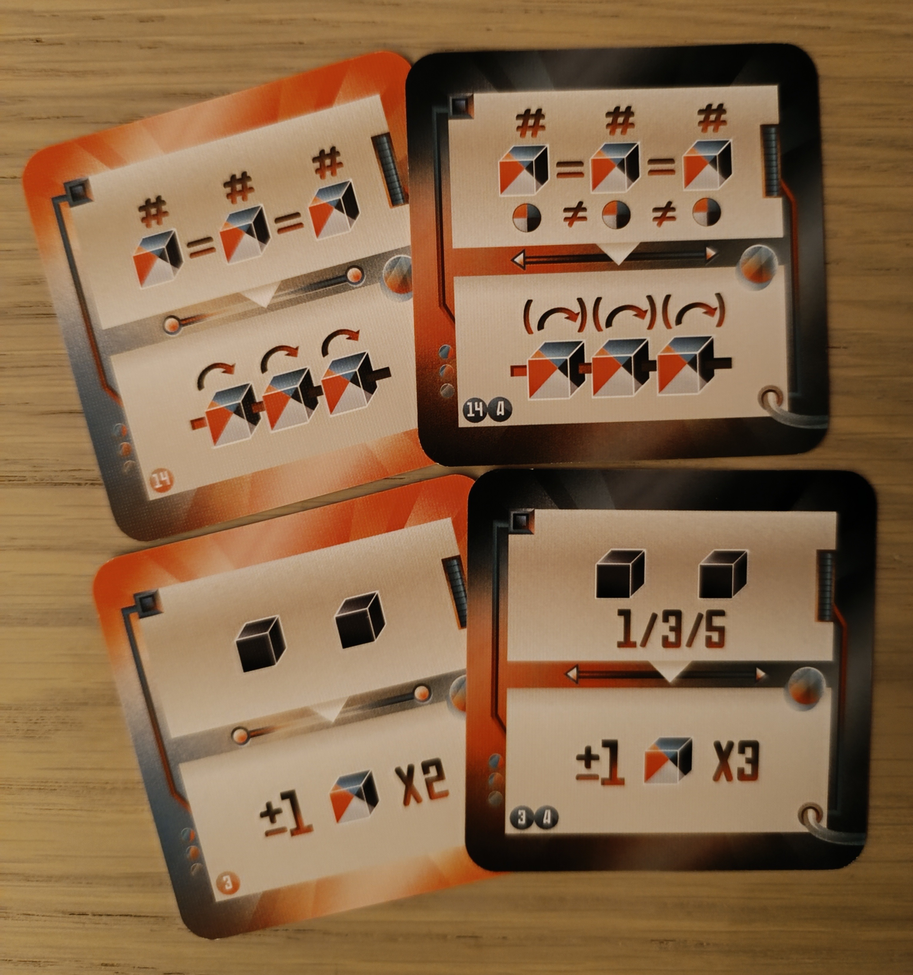 Cartes et leurs versions en difficulté supérieure. Rangée du haut : pour la carte de base, les 3 dés doivent afficher le même chiffre ; pour la carte en difficulté supérieure, les dés doivent également être de couleurs différentes.