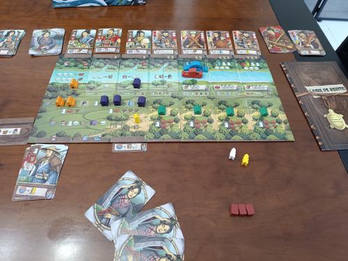 Legacy of Yu game in progress with cards in hand and Story Book visible on the right