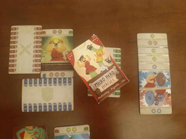 Micro Hero: Hercules card game box alongside labour and technique cards spread on the table