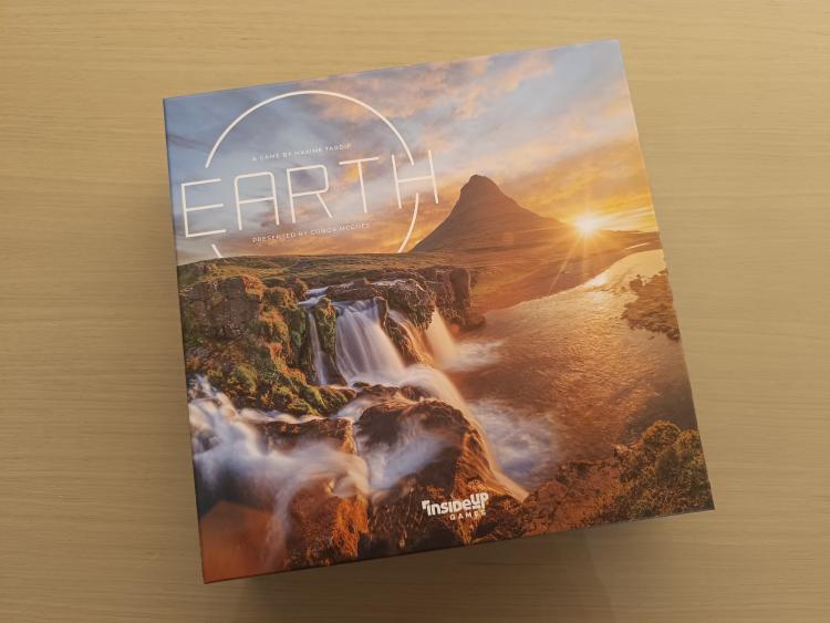 Earth box cover with a waterfall, a mountain and the setting sun