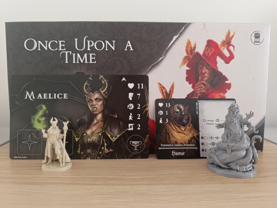 Once Upon a Time box from the Rotas Box with the Maelice mage board and miniature on the left and the Hastur avatar card and miniature on the right
