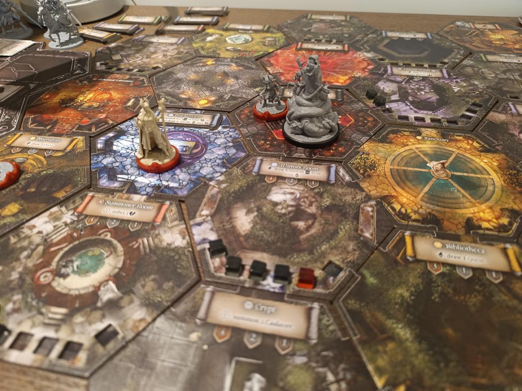 Black Rose Wars: Rebirth Lodge made of hexagonal room tiles, with the Maelice miniature in the Oracle Room and the Hastur miniature nearby